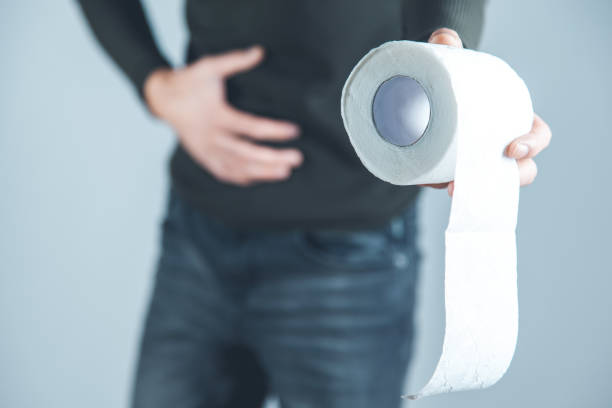 istock man hand in ache belly with toilet paper 1205586400