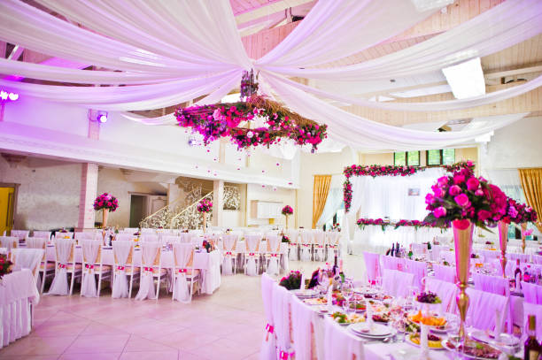 Large group of white tables and chairs for a formal event, such as a wedding reception or anniversary party. 