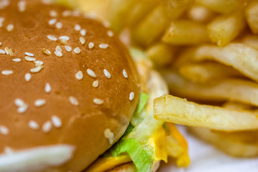 Close up detail of cheeseburger and french fries. Food, junk food and fast food concept