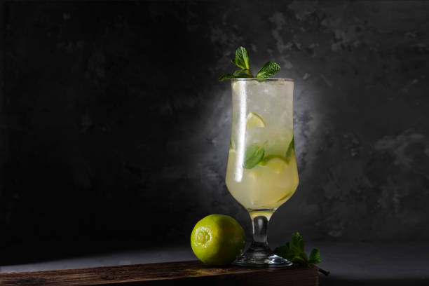 istock Refreshing lime cocktail with mint and ice on a dark background. Soft drink with lime and mint. Close-up. 1205591219