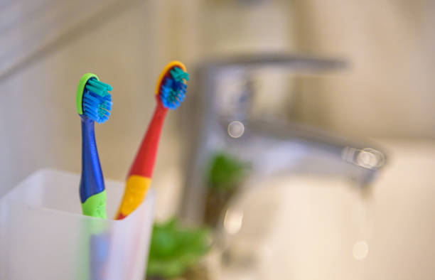 un paio di spazzolini da denti pendono sul muro - scrub brush immagine foto e immagini stock