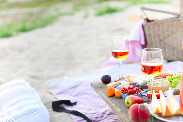 pique-nique sur la plage au coucher du soleil dans le modèle de boho - beach table peach fruit photos et images de collection