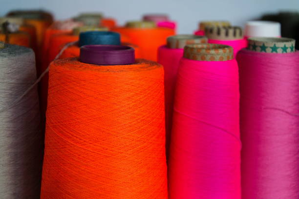 Colorful thread reels set up for sewing machine, textile industry factory concept