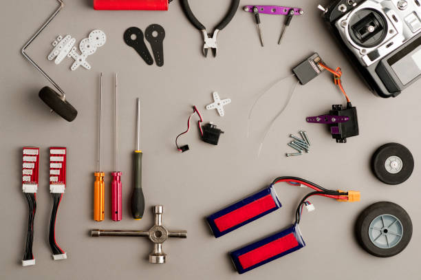istock Drone workshop table, with aero model (RC) control, drone parts, and tools on the gray worktable. Top view 1205594182