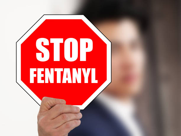 man holding STOP FENTANYL road sign man holding STOP FENTANYL road sign fentanyl stock pictures, royalty-free photos & images