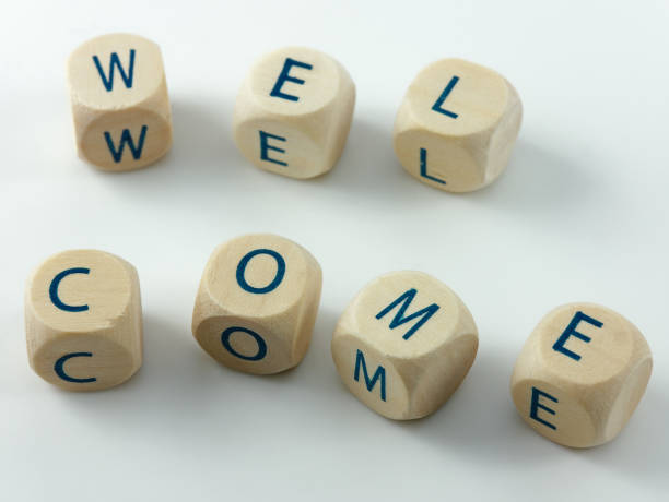 istock Welcome written in wooden cubes on a white desk 1205599006