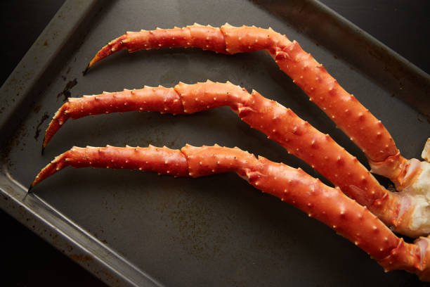 istock Closeup image of fresh crab phalanges on oven-tray over dark background with copyspace 1205603162