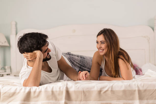 istock Young happy couple lying in bed and having fun 1205603385