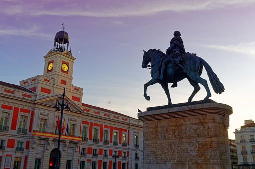 Clock Tower and Equestrian statue of King Charles III, monument on Puerta del Sol in Madrid, Spain at dusk