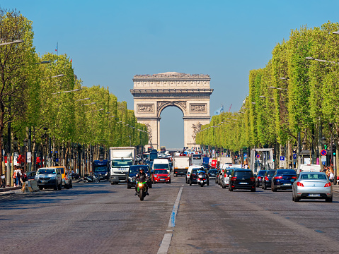 Paris, France - April 2019: traffic on champe elysees with arc de triumph on background
