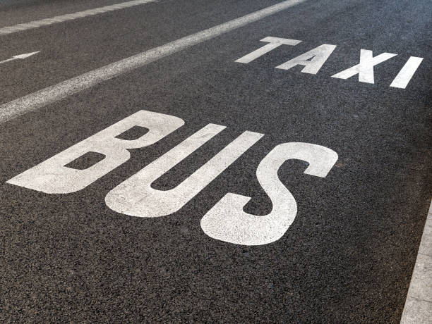 istock Bus taxi lane text on asphalt closeup 1205605105