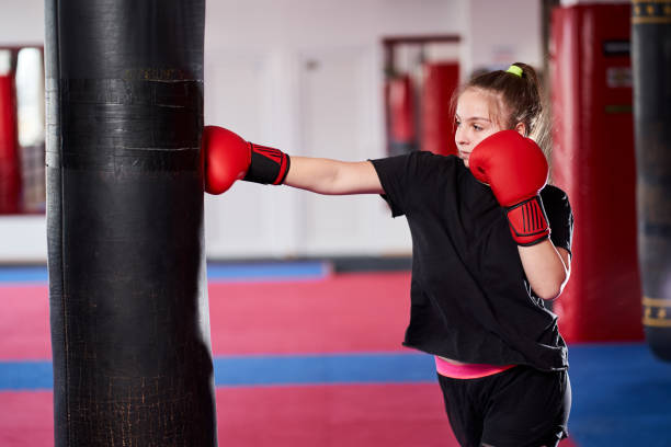 istock Boxer girl hitting the heavy bag 1205606394