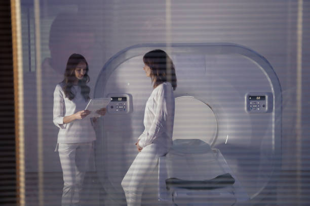 The girl doctor communicates with the patient before the tomography procedure. CT. MRI. Private clinic stock photo