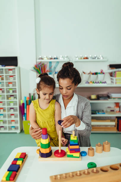 Sharing is caring Teacher and adorable little girl playing at kindergarten teacher classroom child education stock pictures, royalty-free photos & images