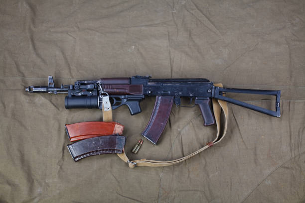 Kalashnikov AK on on canvas background Kalashnikov AK with under barrel grenade launcher on on canvas background ak 47 violence industry black stock pictures, royalty-free photos & images