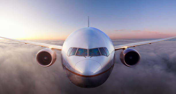 istock Airplane flying above the clouds during colorful sunset or sunrise 1205616035