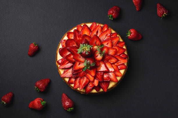 Strawberry Cheesecake top view from above. Strawberry Cheesecake top view from above. A classic decadent dessert, this sweet and delicious homemade baked cheesecake is topped with fresh strawberry slices. The perfect cake for a birthday! dessert topping photos stock pictures, royalty-free photos & images