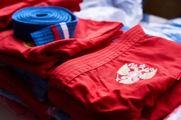 Sport uniform with coat of arms of Russian federation folded and lying on the table with many other equipment