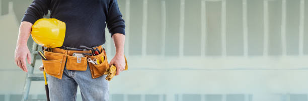 istock Contractor With Tool Belt and Hard Hat In Front of Drywall Banner 1205632229