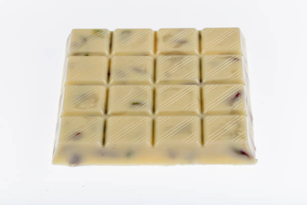 istock White chocolate bars on table with chocolate tower. Chocolate and pistachio. 1205636755