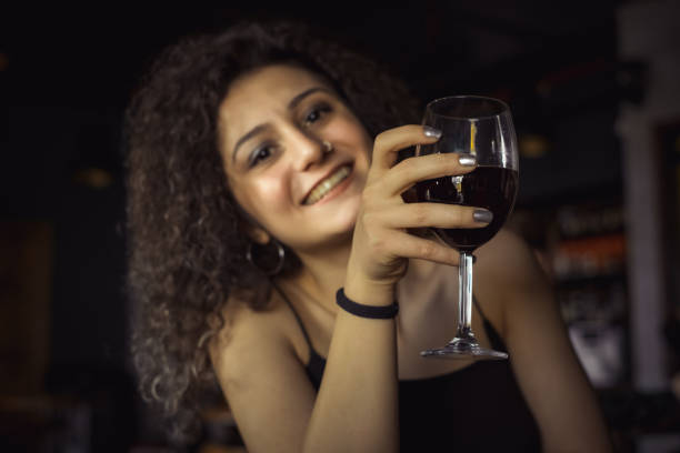 istock young woman drinking wine in pub 1205636812