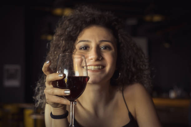 istock young woman drinking wine in pub 1205638213