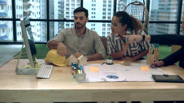 Creative business people group having conversation at office desk in workplace.