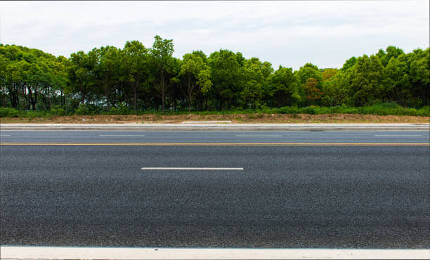 New asphalt roads, trees under blue sky and white clouds