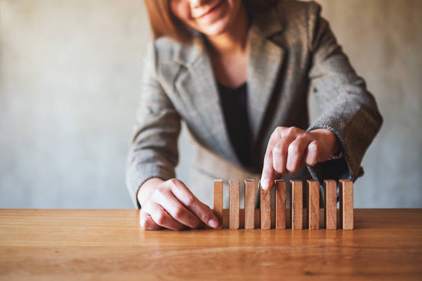 businessman putting wooden block in a row on the table for business concept Closeup image of businessman putting wooden block in a row on the table for business concept Distracted stock pictures, royalty-free photos & images