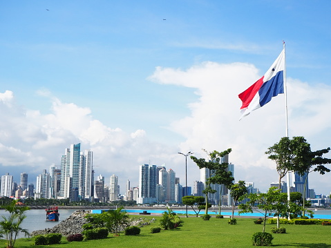 Panama city centre park with a flag and ocean.