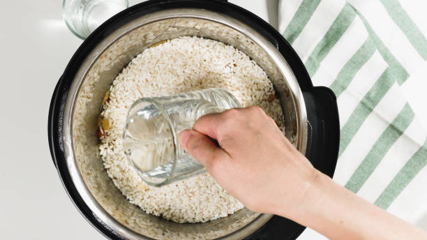 cocinar arroz con carne y verduras en presión multi cooker paso a paso, vista superior. vertiendo agua en una olla. - fried onion roasted chopped fotografías e imágenes de stock