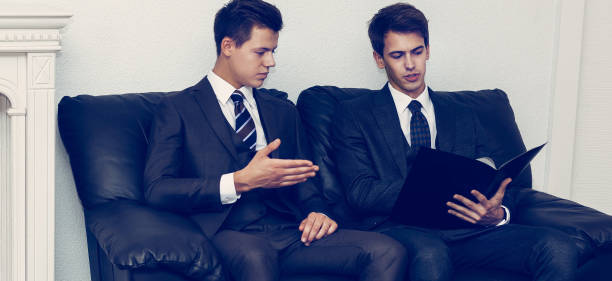 istock business partners discussing documents sitting on the sofa in the meeting room 1205654818