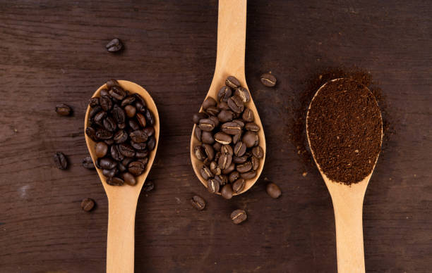 istock Roasted coffee in a spoon on the table Coffee on wood 1205654841