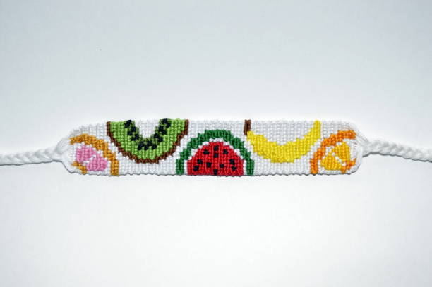 istock White designer unique friendship bracelet handmade of threads with fruit pattern isolated on white background 1205659387