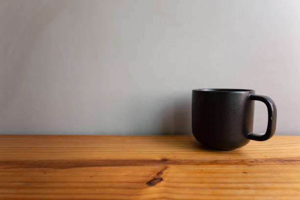 istock a cup of coffee or tea on wood table and gray wall 1205661566