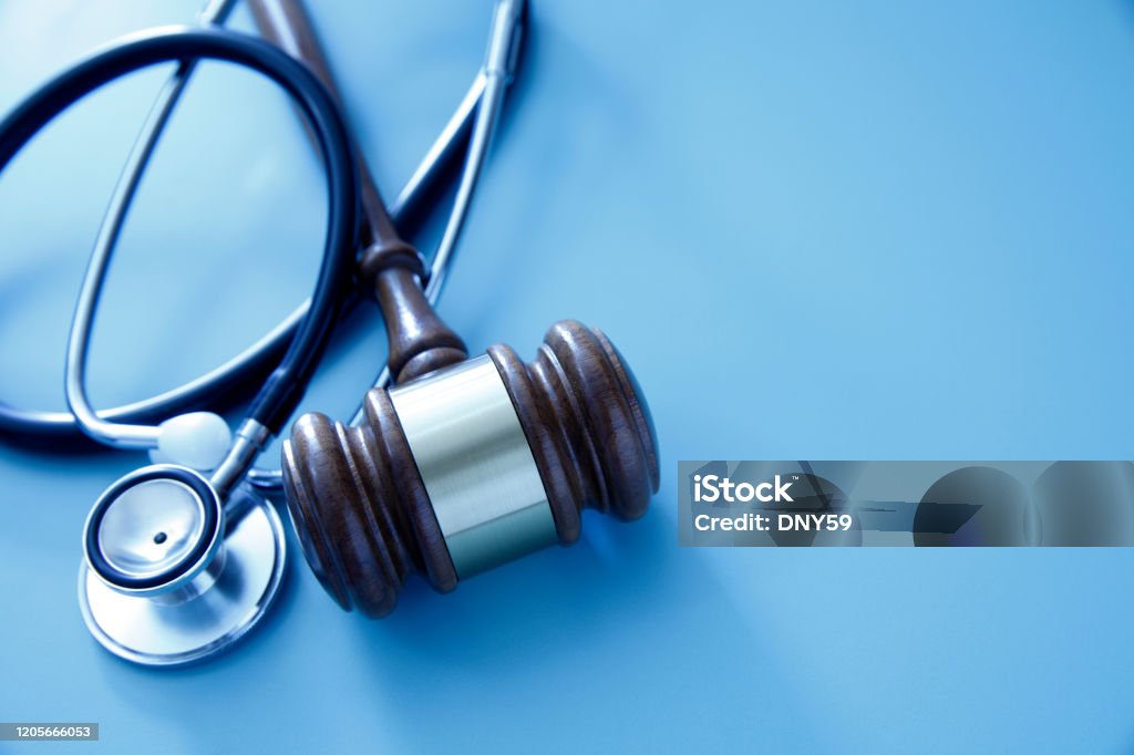Gavel And Stethoscope A gavel and a stethoscope on a blue background representing the intersection of the medical and legal industries. Healthcare And Medicine Stock Photo