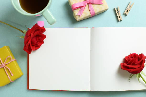 Empty note paper with red rose flower, black coffee, gift boxes on mint green background. Flat lay, top view, copy space Empty note paper with red rose flower, black coffee, gift boxes on mint green background. Flat lay, top view, copy space book heart shape valentines day copy space stock pictures, royalty-free photos & images