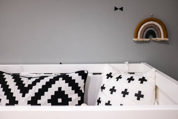 istock Black and white pillows and rainbow fabric on a wall on a grey decoration bedroom in a domestic house 1205670508