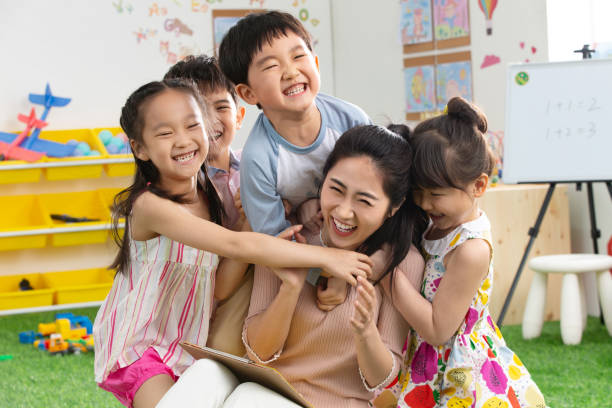 istock Kindergarten teachers and children embrace together 1205673019