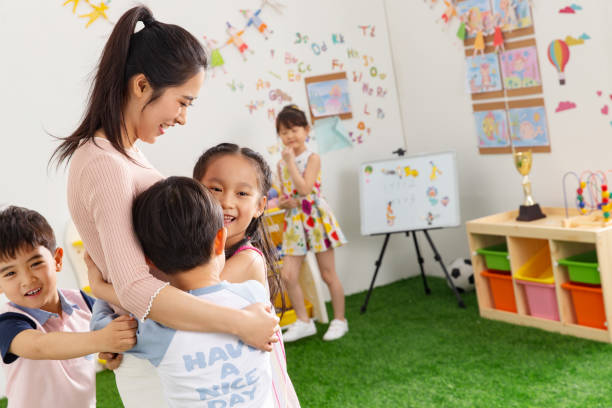 istock Kindergarten teachers and children embrace together 1205673044