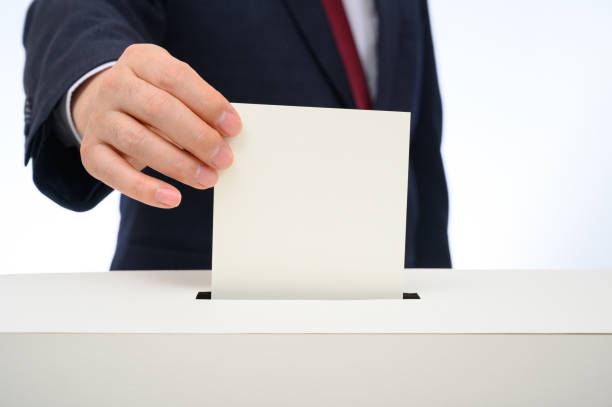 Man's hand down the ballot in the ballot box. stock photo
