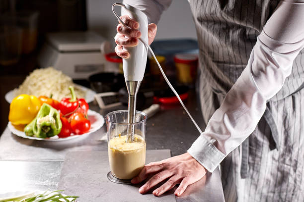 battre de la mayonnaise maison avec de l’huile d’olive. mélanger les ingrédients pour la sauce. le chef utilise un mélangeur. préparation de sauce étape par étape - corolle photos et images de collection