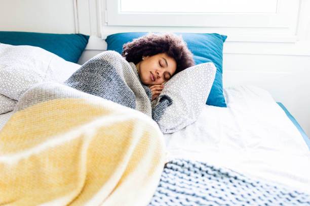 african american woman taking a nap in a bed. - sleeping women bed pillow imagens e fotografias de stock