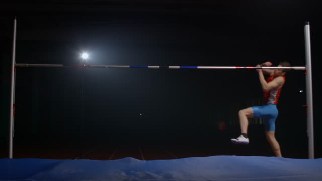 A professional athlete performs a jump over a crossbar and knocked down the bar during a high jump.