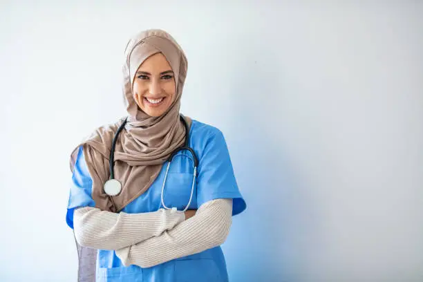 Closeup portrait of friendly, smiling confident muslim female nurse. Authentic Confident Middle Eastern Healthcare Worker. Middle age arab nurse woman wearing hijab over isolated background