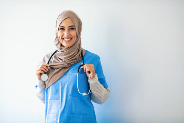 mittleres alter arabische krankenschwester frau trägt hijab über isolierten hintergrund - healthcare and medicine nurse doctor general practitioner stock-fotos und bilder