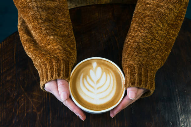 istock Cup of cappuccino with latteart in hands. 1205683501