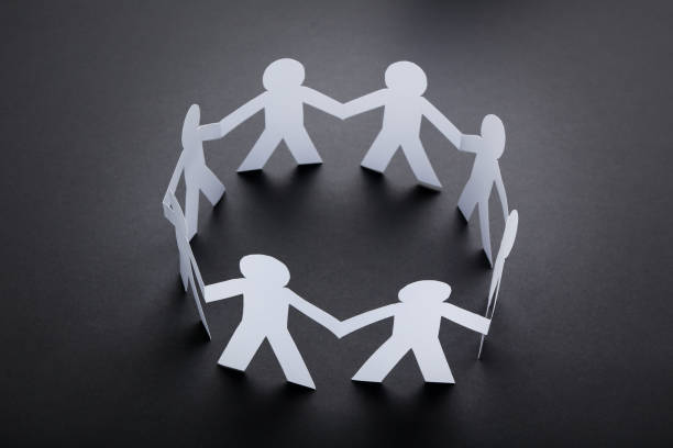 istock Paper chain people on black background 1205685570