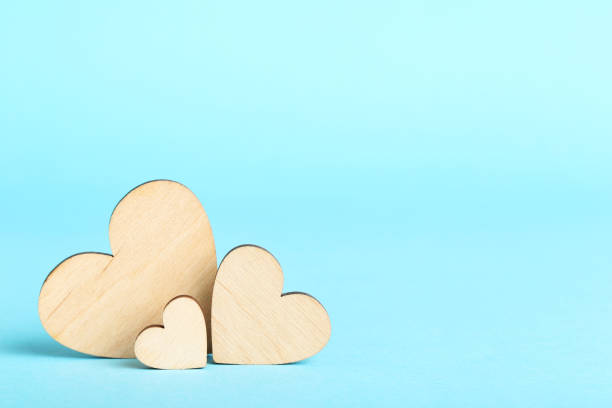istock Brown wooden hearts on blue background 1205687358