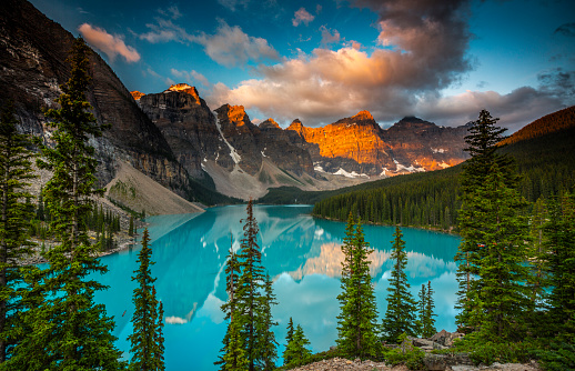 Moraine Lake in Banff National Park at sunset. Mountains of famous Ten Peaks reflecting in the beautiful calm turquoise water of the lake. Banff National Park, Alberta province in Canada.